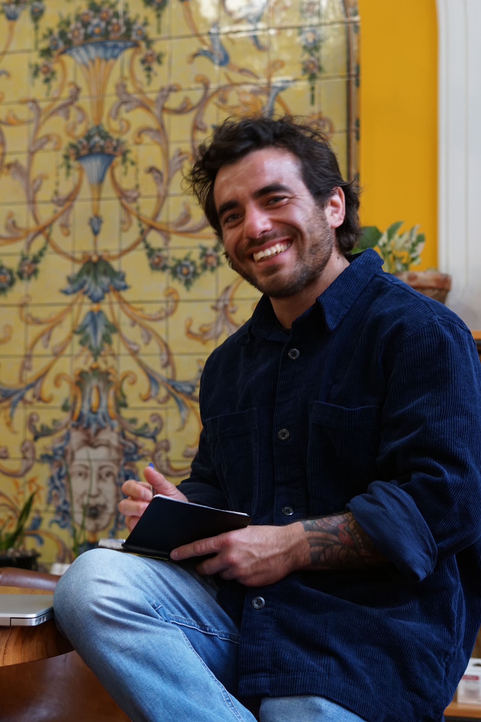 Tomás Baeza sonriendo con su cuaderno
